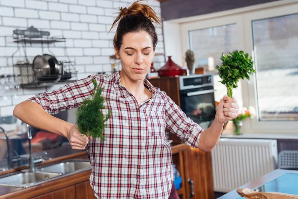 Mujer feliz sosteniendo eneldo y dacing en la cocina — Foto de Stock