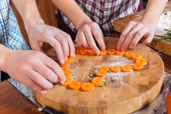 Paar maken hart met gesneden wortelen op de keuken — Stockfoto