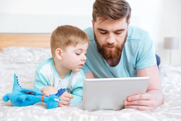 Vater und Sohn nutzen gemeinsam Tablet zu Hause — Stockfoto