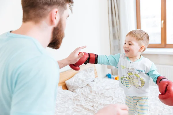 Père jouant avec son fils en gants de boxe à la maison — Photo