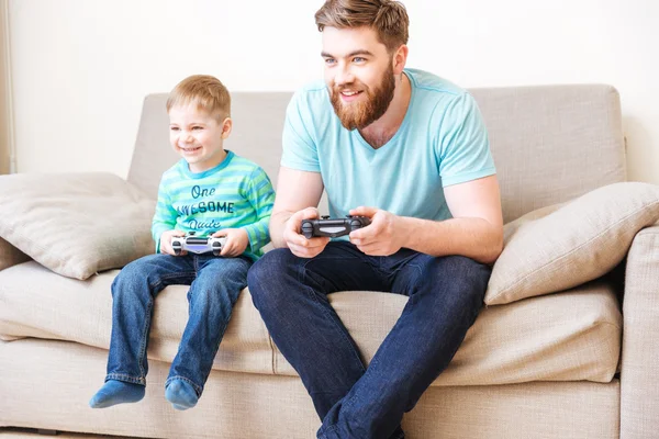 Niño feliz jugando juegos de ordenador con su padre en casa —  Fotos de Stock