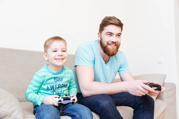 Feliz padre e hijo pequeño jugando videojuegos —  Fotos de Stock