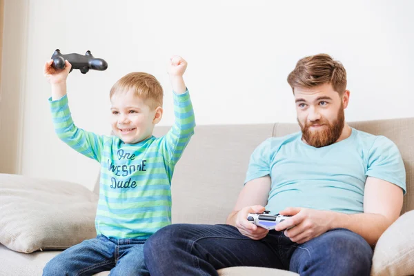 Pequeño hijo jugando juegos de ordenador con el padre y ganando —  Fotos de Stock