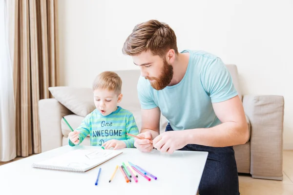 Padre e figlio disegnano in salotto a casa — Foto Stock