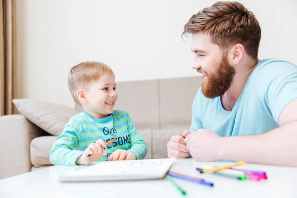 Cheeful pequeno filho e pai desenho em casa — Fotografia de Stock