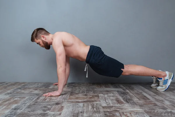 Aantrekkelijke bebaarde jonge man doen push-ups — Stockfoto