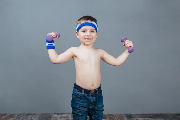 Gelukkig schattige kleine jongen permanent en het doen van oefeningen met halters — Stockfoto