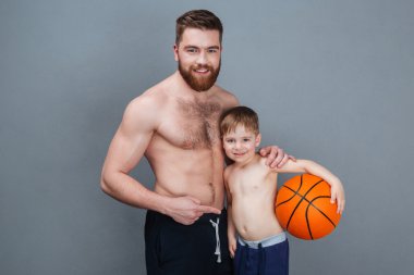 Mutlu gömleksiz baba ve oğlu basketbol topu tutan 
