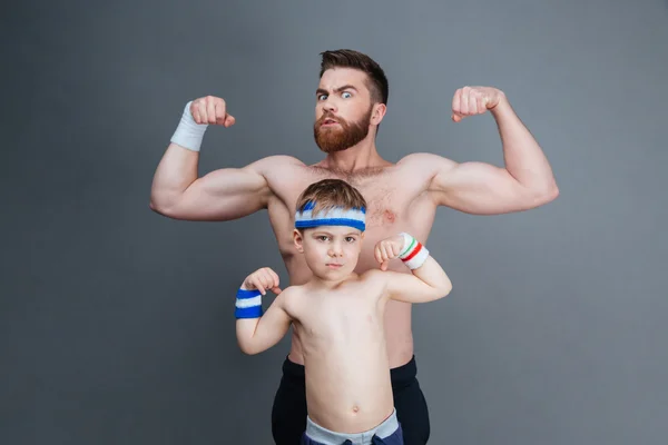 Hombre barbudo fuerte y su hijo mostrando bíceps — Foto de Stock