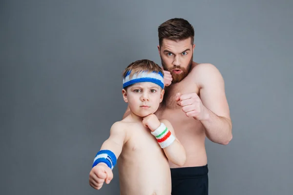 Sérieux père barbu et son petit fils frappant à la caméra — Photo