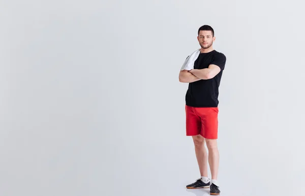 Hombre de fitness de pie con los brazos cruzados — Foto de Stock