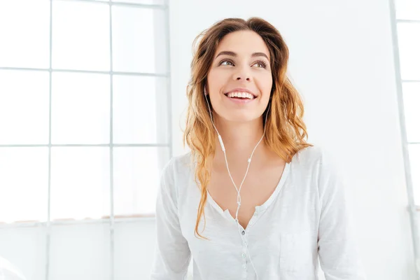 Happy thoughtful woman with earphones — Stock Photo, Image