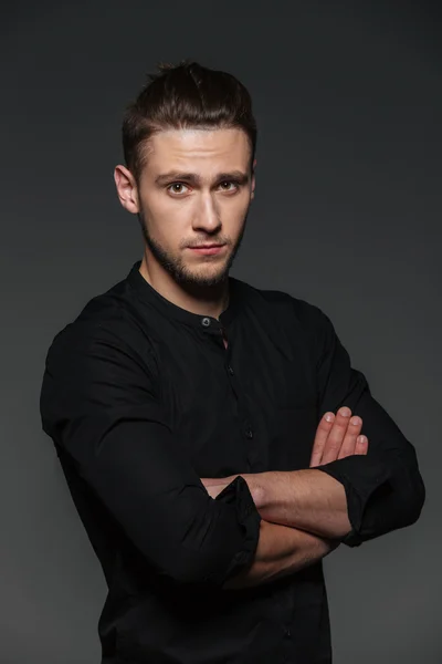 Portrait of attractive confident young man standing with arms crossed — Stock Photo, Image