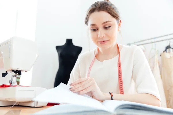 Mulher focada costureira leitura notas e trabalho — Fotografia de Stock