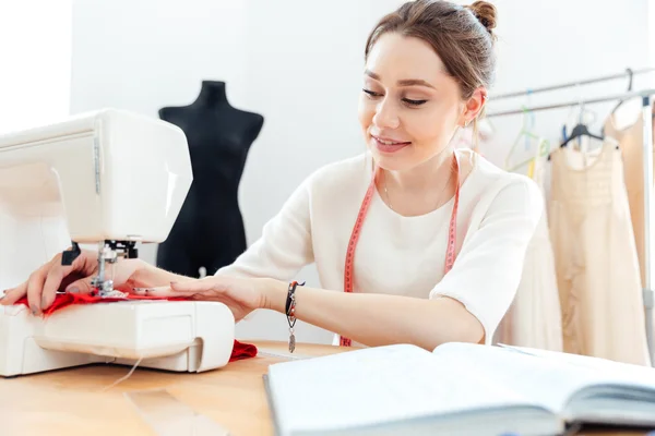 Mujer sonriente costura costura en la máquina de coser —  Fotos de Stock