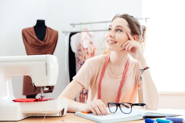 Happy seamstress thinking and working in studio — Stock Photo, Image