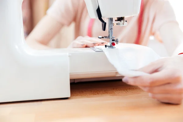 Woman seamstress sews clothes and put thread in needle — Stock Photo, Image