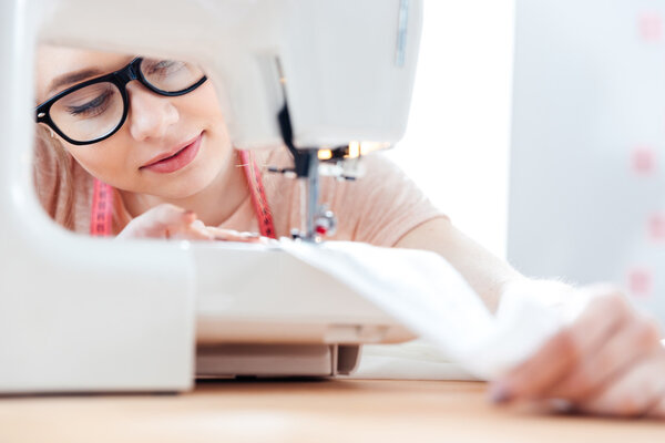 Концентрированная швея за работой с тканями
