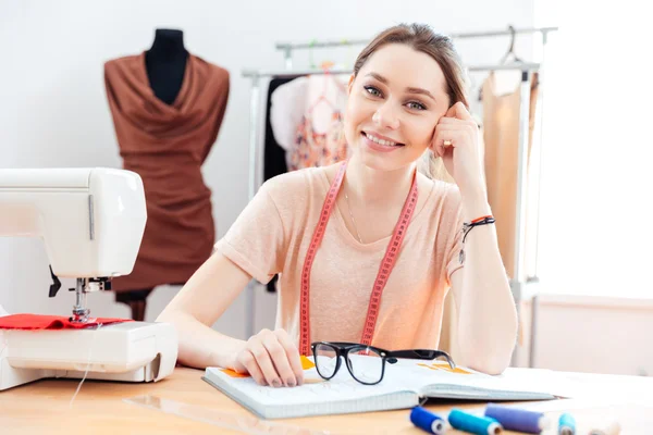 Femme joyeuse couturière travaillant dans un atelier de couture — Photo