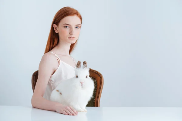 Frau sitzt mit Kaninchen am Tisch — Stockfoto