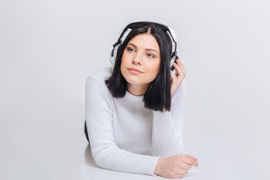 Kulaklık ile yerde yatarken genç güzel kadın