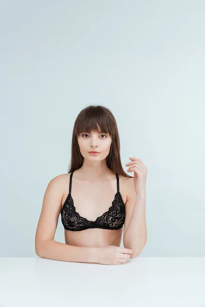 Charmante vrouw in lingerie zitten aan de tafel — Stockfoto