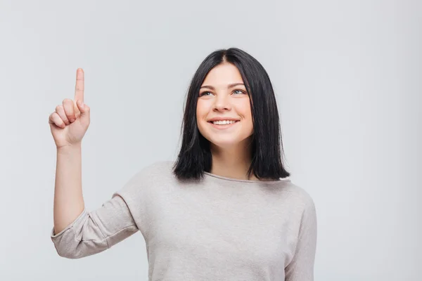Porträtt av en ganska ung brunett tjej pekande finger upp — Stockfoto
