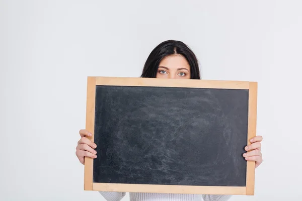 Mladá brunetka se vztahuje na její tvář s prázdnou tabuli — Stock fotografie