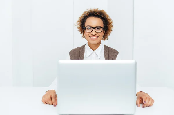 Mujer de negocios afroamericana feliz trabajando con computadora portátil en el lugar de trabajo — Foto de Stock