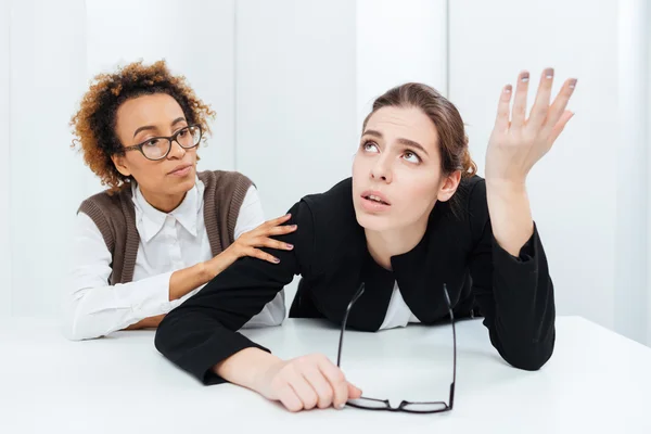 Pretty african american businesswoman supporting her upset despaired colleague