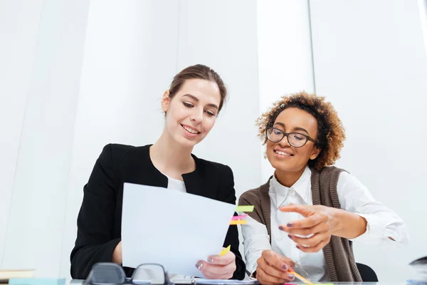 Deux femmes d'affaires joyeux travaillant avec des documents ensemble — Photo