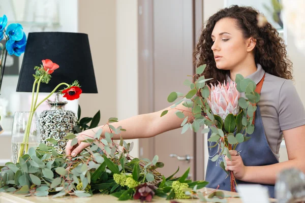 店で新鮮な花で花束を作る女性花屋を集中してください。 — ストック写真