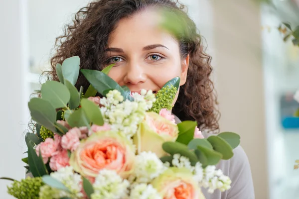 Happy woman holding bouquet of flowers and smiling — Stock Photo, Image