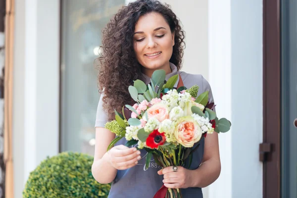 Kadın çiçekçi çiçek buketi ayakta salonu önünde ile — Stok fotoğraf