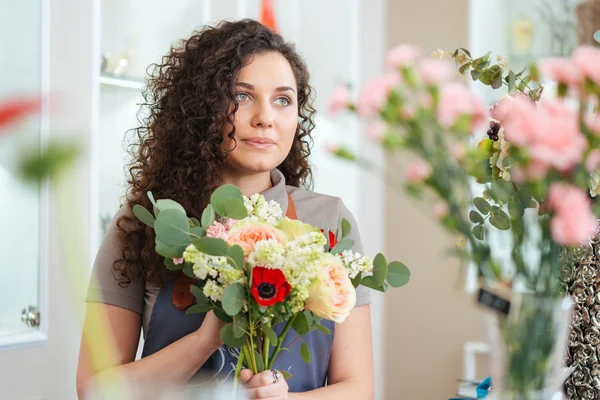 Linda florista jovem de pé na loja de flores — Fotografia de Stock