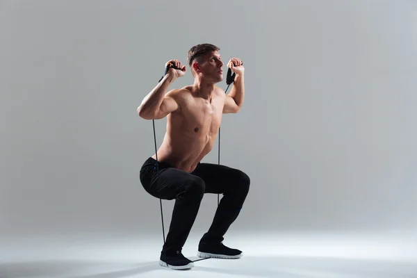 Fitness homem agachamento com expansor — Fotografia de Stock