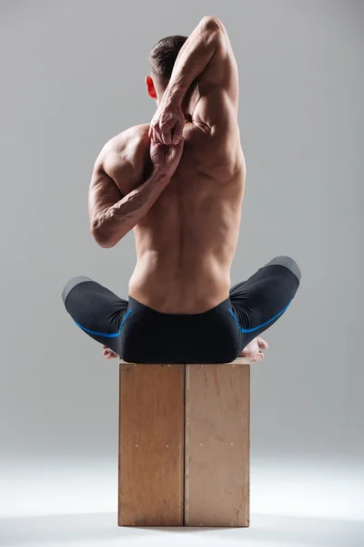 Człowiek siedzi na drewniane pudełko i wyciąganie ręki — Zdjęcie stockowe