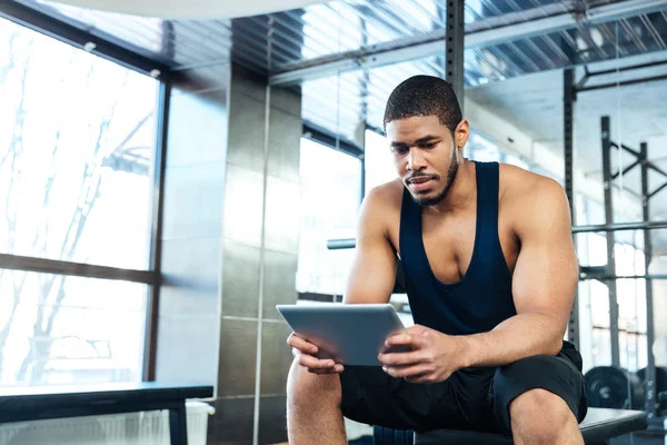 Człowiek fitness z komputera typu tablet w siłowni — Zdjęcie stockowe