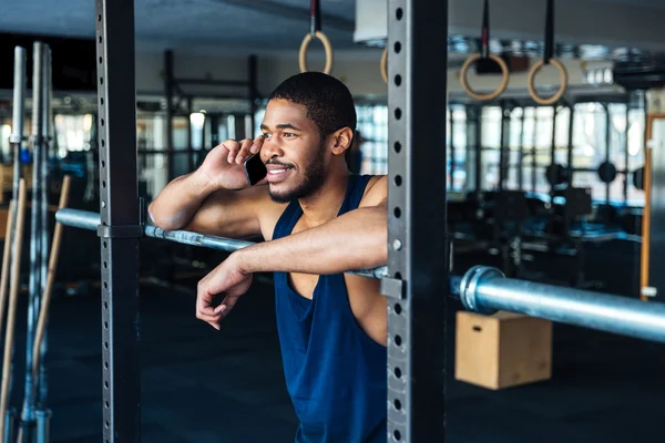 Здоровый фитнесмен разговаривает по смартфону в спортзале — стоковое фото