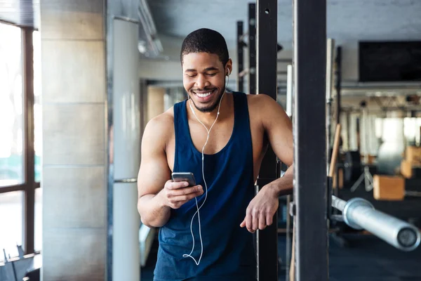 Homem de fitness usando smartphone no ginásio — Fotografia de Stock