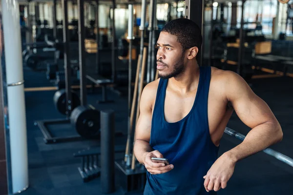 Afro americano bodybuilder ragazzo in possesso di smartphone — Foto Stock