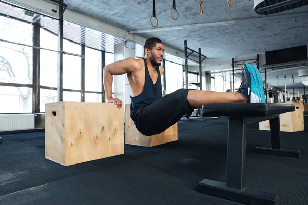 Ισχυρή γυμναστήριο άνθρωπος κάνει τους μυς ασκήσεις στο γυμναστήριο — Φωτογραφία Αρχείου