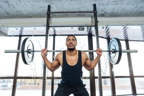 Handsome muscular weightlifter at gym doing squats — Stock Photo, Image