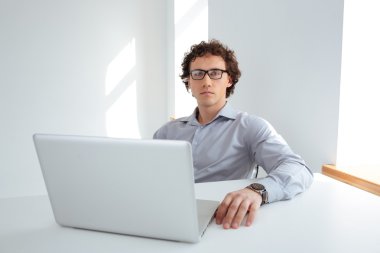 İşadamı ofiste dizüstü bilgisayarda çalışıyor.