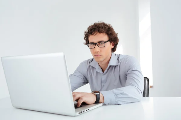 Бизнесмен в очках, работающий на ноутбуке — стоковое фото