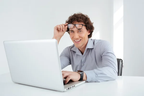 Hombre de negocios sonriente trabajando en el ordenador portátil — Foto de Stock