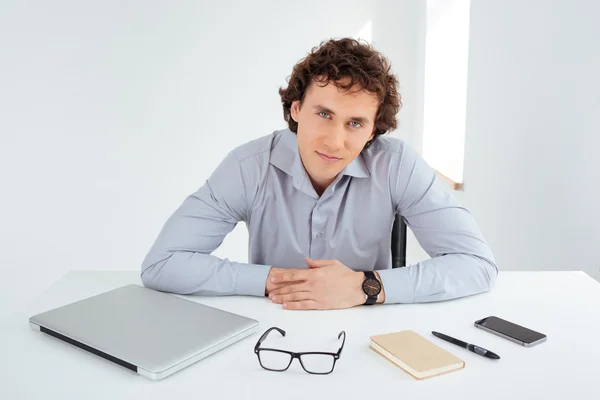 Hombre de negocios guapo sentado en su lugar de trabajo — Foto de Stock