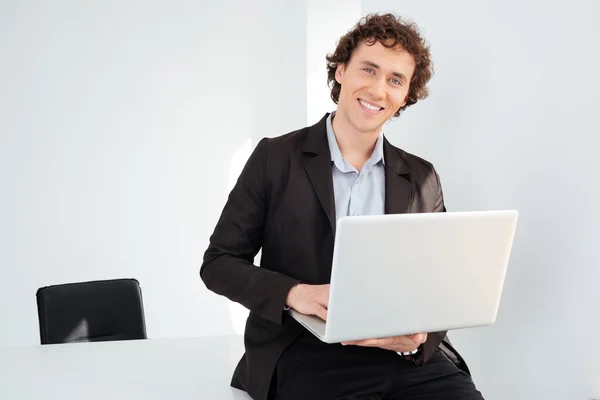 Geschäftsmann lehnt mit Laptop auf dem Tisch — Stockfoto