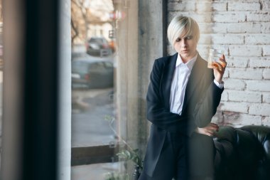 Bir bardak viski ile kısa saçlı sarışın kız