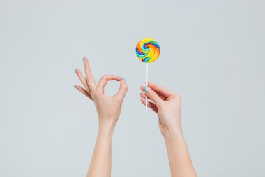 Lolipop tutan ve parmaklar ok işaretiyle gösterilen eller